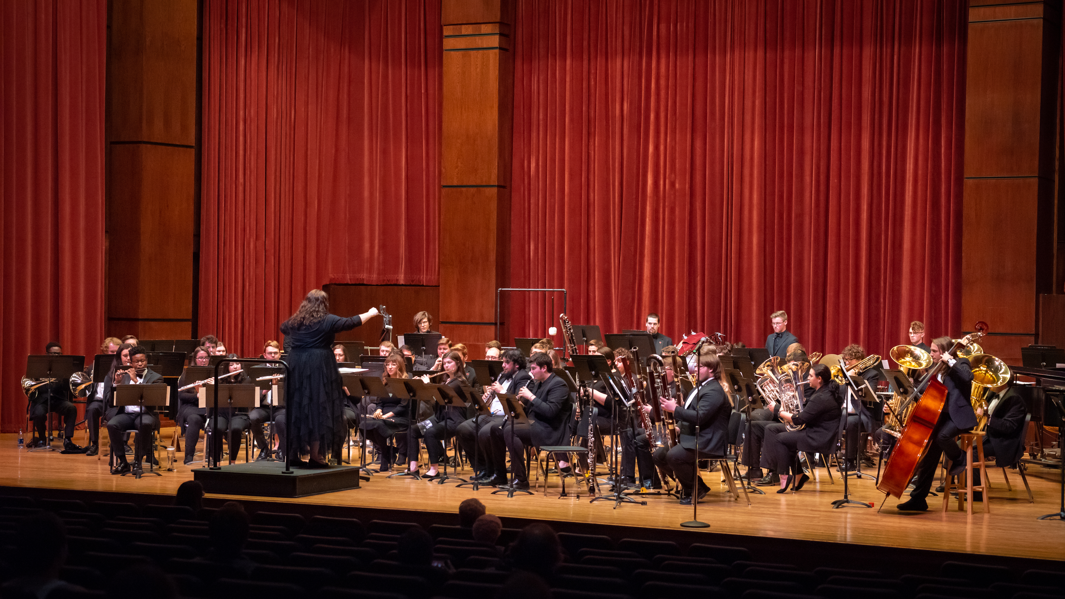 Symphonic Winds band on stage with conductor in front of the ensemble